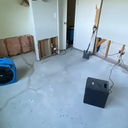 An air mover running on the floor of a room being dried after a water loss
