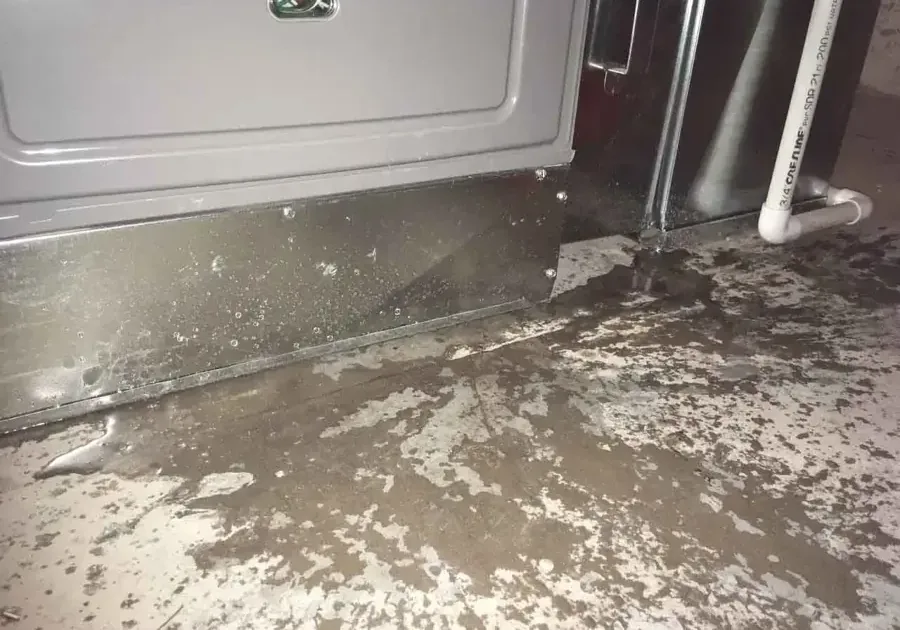 Condensate water pooled on the floor beneath an indoor AC unit
