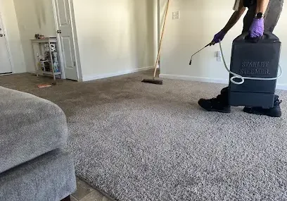 Technician running a portable extractor over a soaked carpet