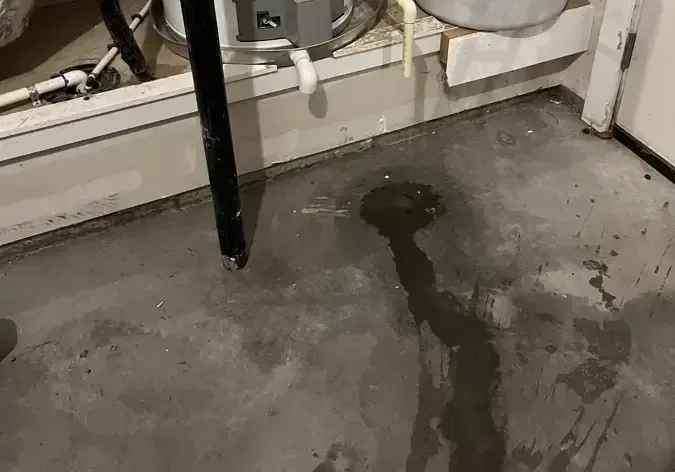Water spreading across a garage floor from a leaking water heater